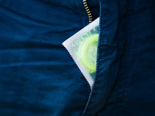 Free photo close-up green condom and jeans zip