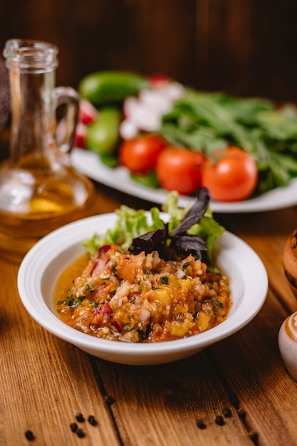 Foto gratuita chiuda in su dell'insalata arrostita della melanzana con la cipolla e le erbe del peperone dolce del pomodoro