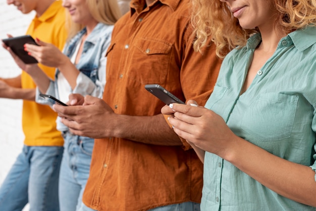 Foto gratuita gruppo di amici del primo piano con i telefoni cellulari