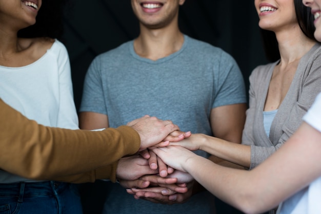 Free photo close-up group of positive people holding hands