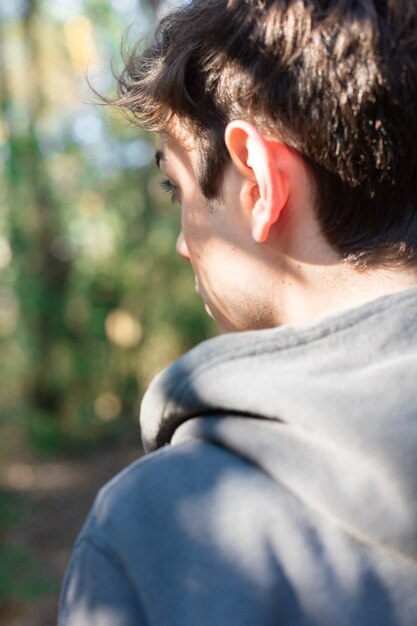 Close-up of guy in the forest on a sunny day