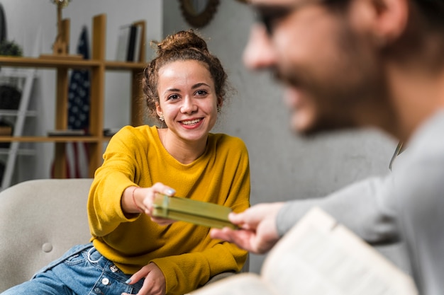 Foto gratuita ragazzo del primo piano che dà a ragazza un libro