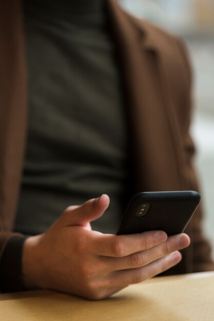 Close-up guy holding his smartphone