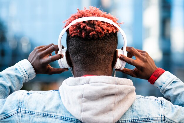 Close-up guy with headphones and jeans jacket