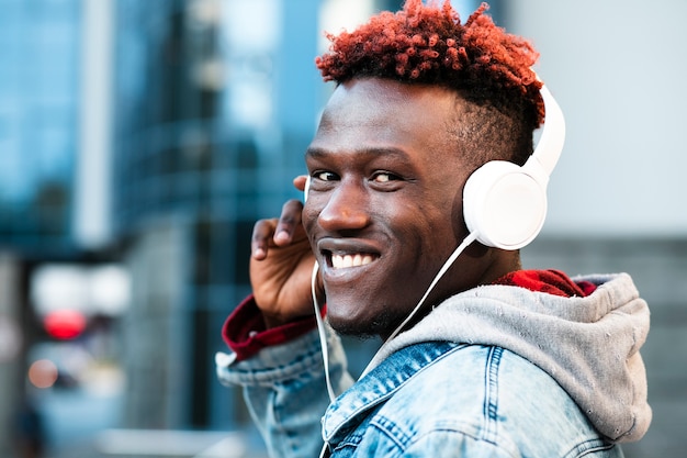 Foto gratuita ragazzo del primo piano con le cuffie e l'ampio sorriso