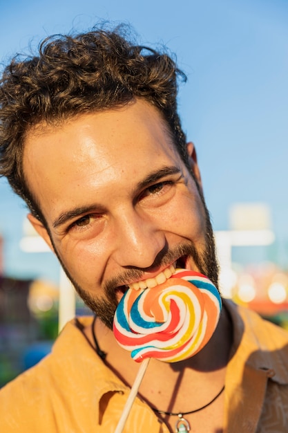 Free photo close-up guy with lollipop looking at camera