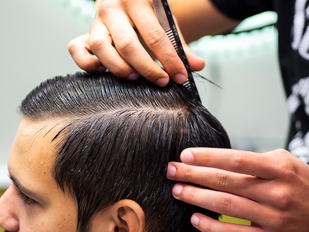 Close-up hairdresser combing hair