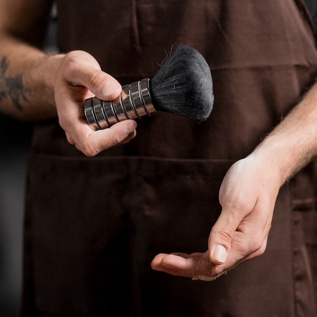 Close-up of a hairdresser's hand holding shaving brush