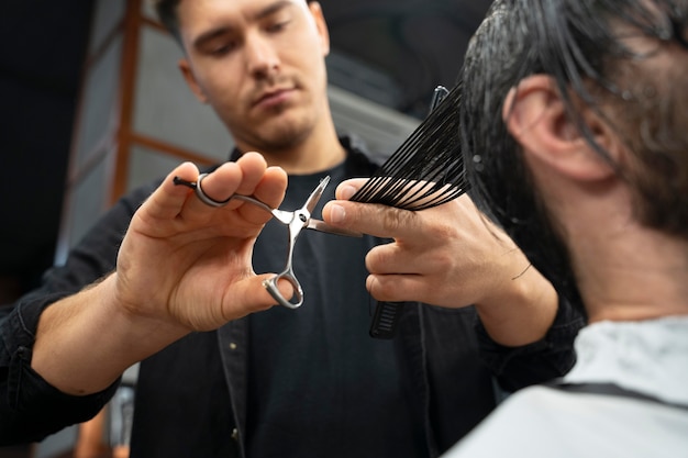 Close up hairdresser using scissors