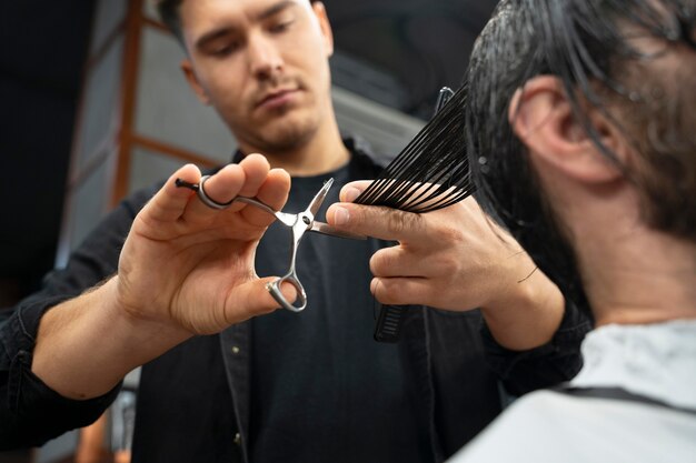 Крупным планом парикмахер, используя ножницы