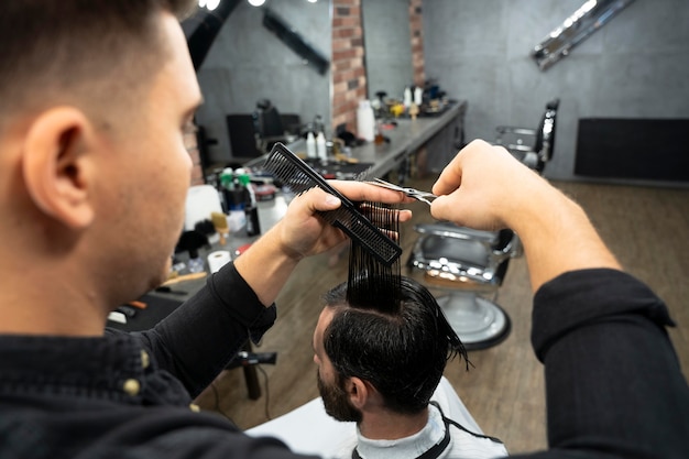 Close up hairdresser using styling tools