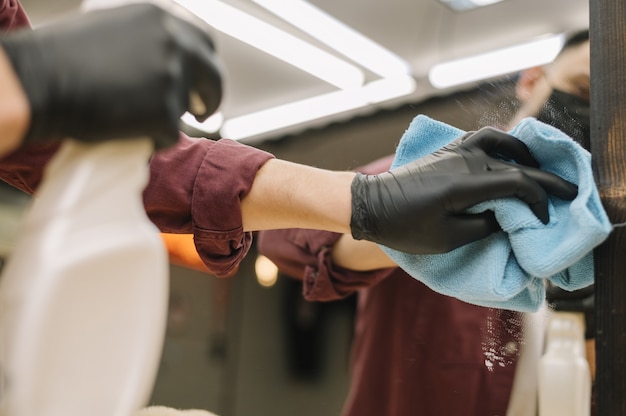 Free photo close-up of hairstylist cleaning the mirror