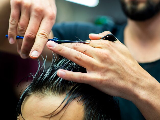 Close-up of hairstylist cutting hair