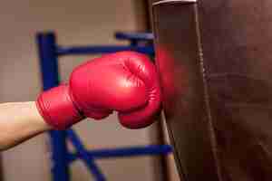 Free photo close-up hand of boxer at the moment of impact on punching bag