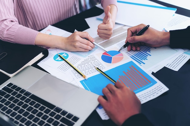 Free photo close up hand of business man busy at office desk on notebook and documents working