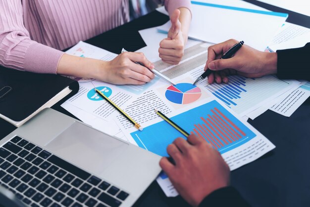 close up hand of Business man busy at office desk on Notebook and documents working