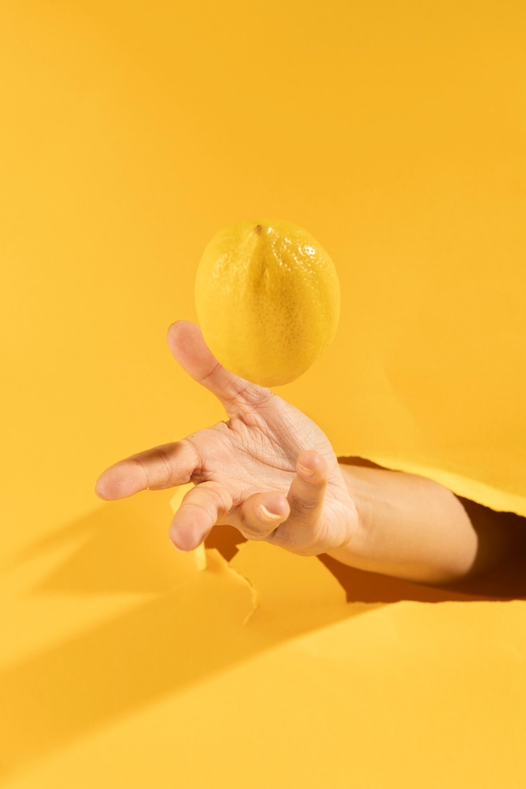 Free Photo close-up hand catching raw lemon