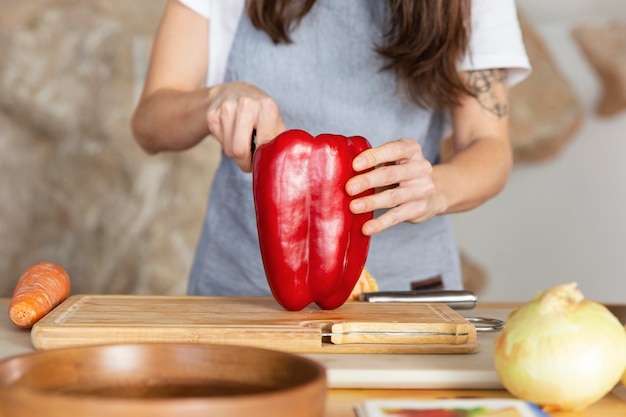 Free photo close up hand cuttin bell pepper