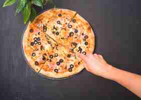 Free photo close-up of hand cutting pizza with sharp knife