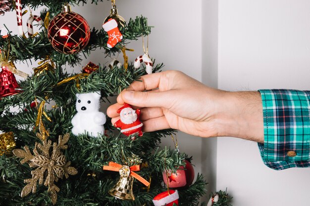 Close up of hand decorating christmas tree