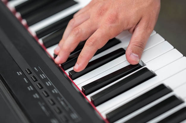 Крупным планом рука на цифровом пианино высокий вид
