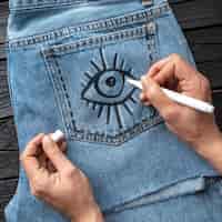 Free photo close-up hand drawing on jeans