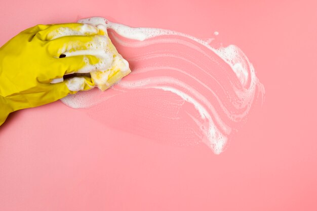 Close-up hand in glove cleaning surface