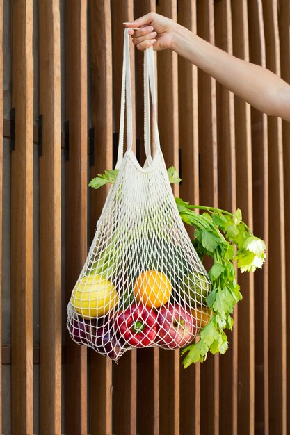 Close up hand holding bag with vegetables