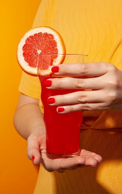 Free photo close-up hand holding blood orange juice