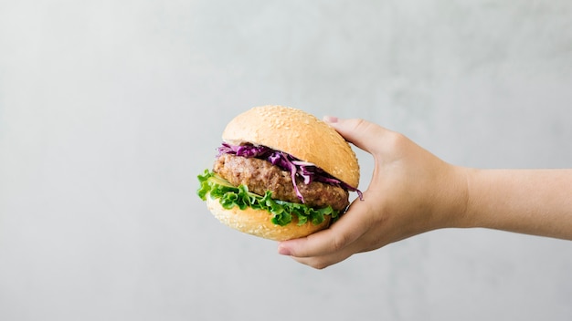 Close-up hand holding burger