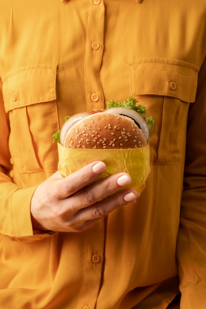 Foto gratuita hamburger che tiene la mano ravvicinata