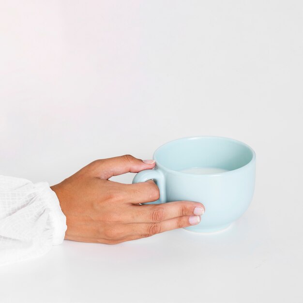 Close-up hand holding ceramic mug