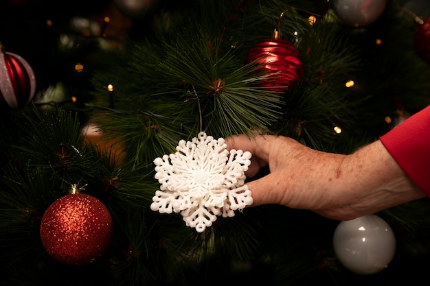 Foto gratuita ornamento di natale della holding della mano del primo piano