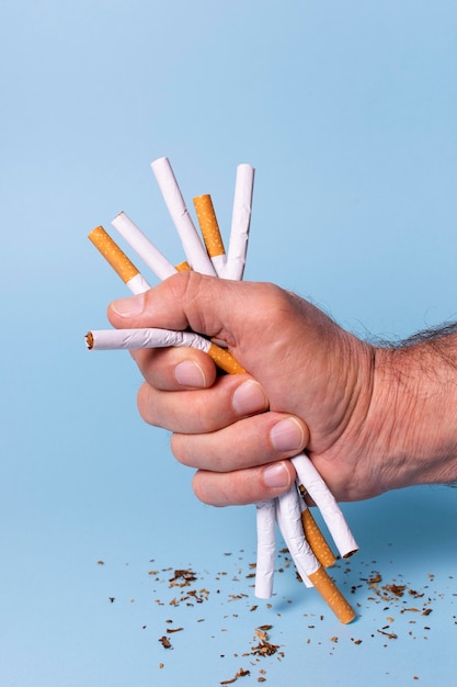 Free photo close-up hand holding cigarettes