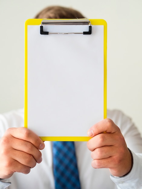 Close-up hand holding a clipboard mock-up