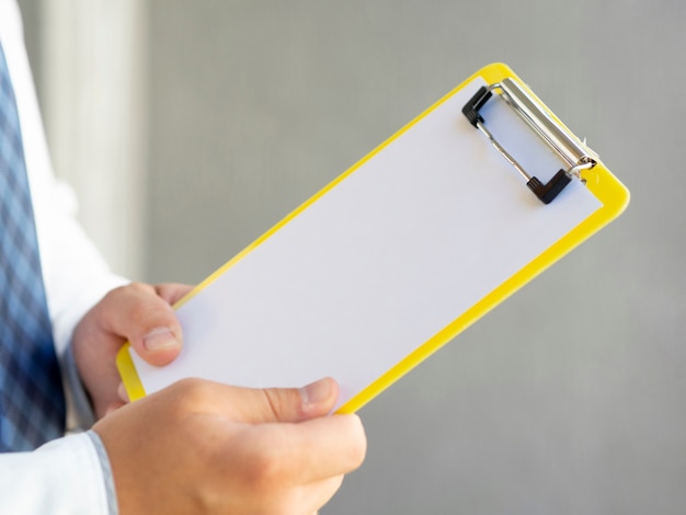 Close-up hand holding a clipboard mock-up