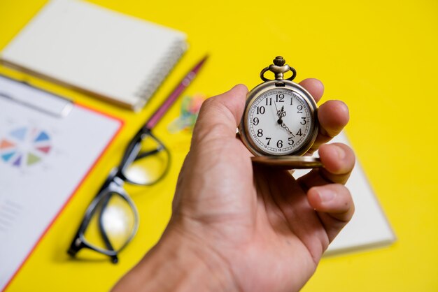 Close up hand holding clock