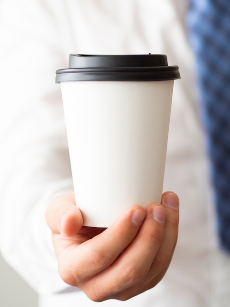 Макро рука держит чашку кофе макет