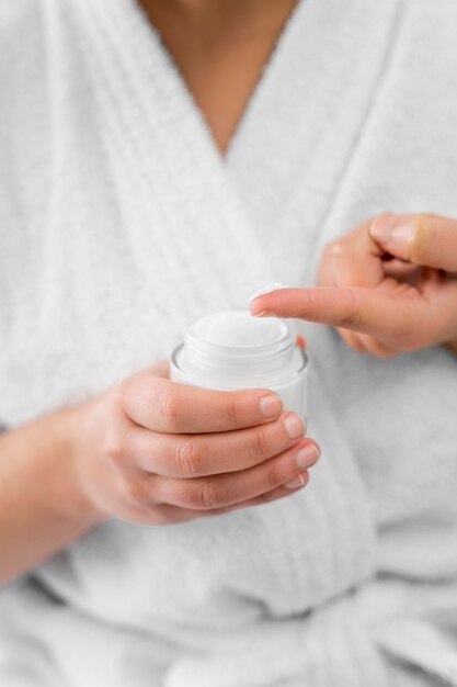 Close-up hand holding cream container