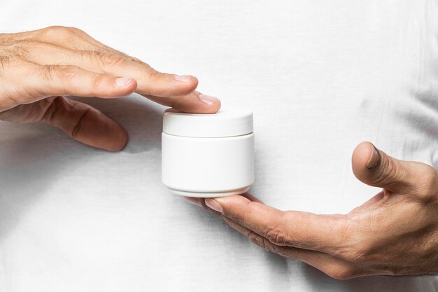 Close-up hand holding cream container