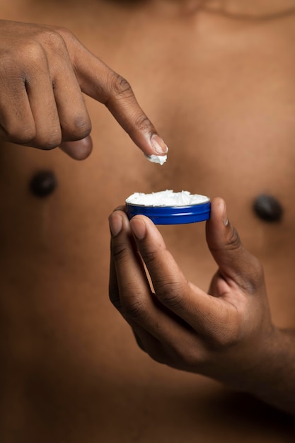 Close up hand holding cream container