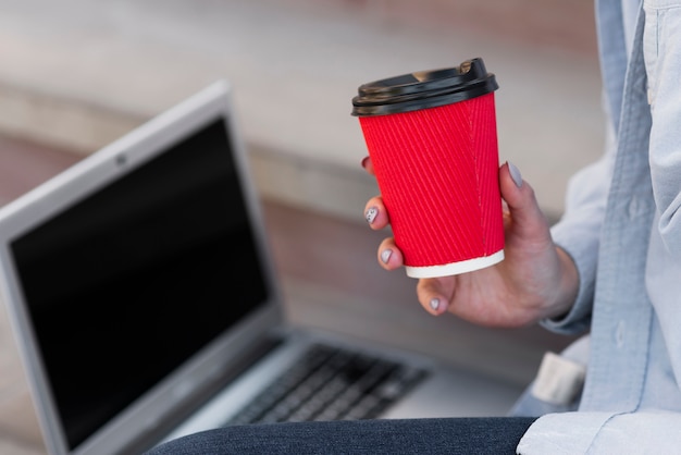 Foto gratuita mano del primo piano che tiene una tazza di caffè