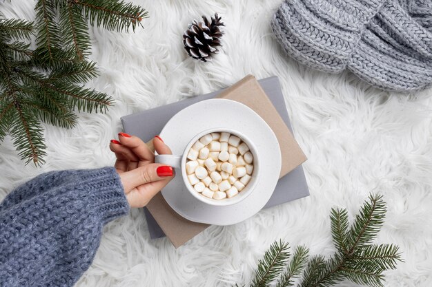 Close up hand holding cup with marshmallows