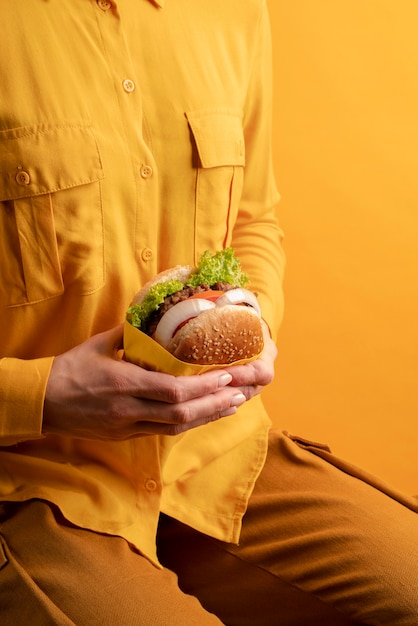 Free photo close up hand holding delicious burger