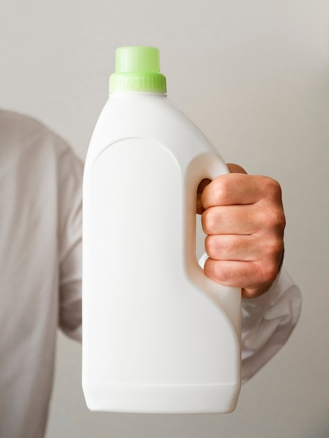 Free photo close-up hand holding detergent bottle mock-up