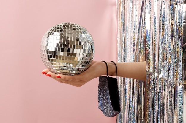 Free photo close up hand holding disco ball