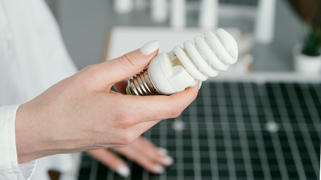 Free photo close up hand holding eco lightbulb side view