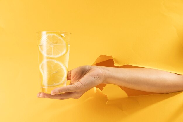 Close-up hand holding glass of lemonade