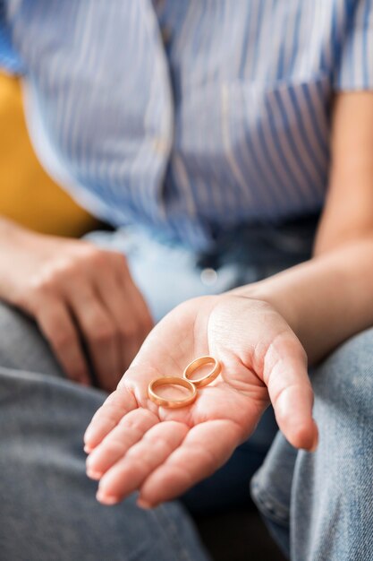 黄金の結婚指輪を持っているクローズアップ手