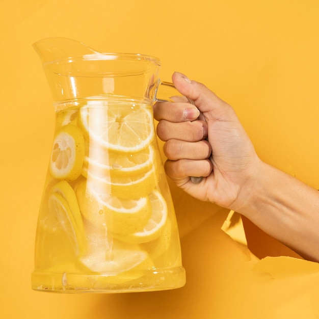 Free photo close-up hand holding jar of lemonade